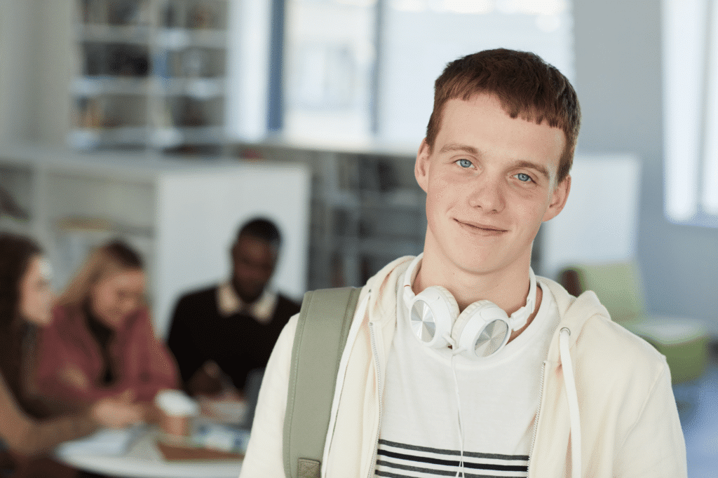 portrait-of-smiling-young-man-in-library-2023-11-27-05-04-17-utc