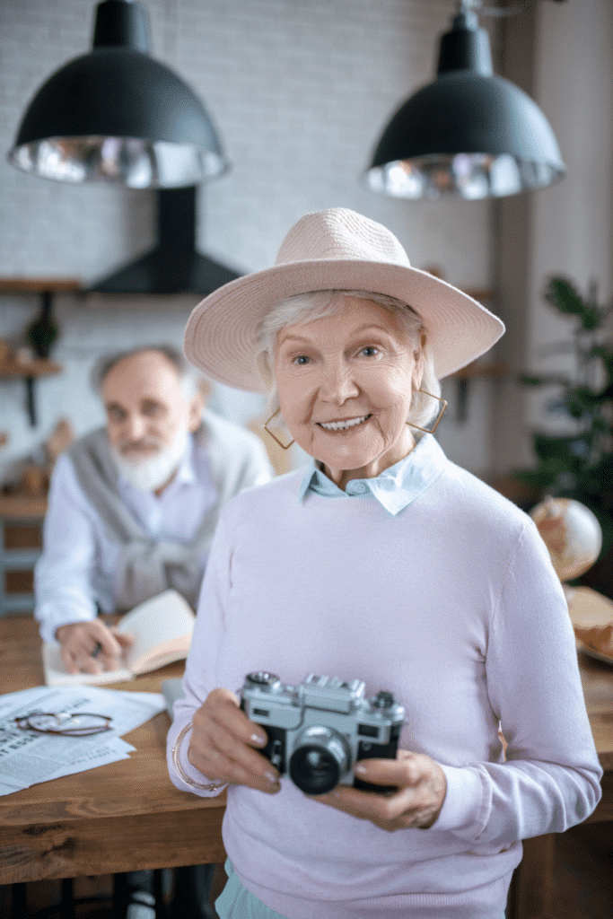 smiling-senior-woman-using-a-film-camera-2024-10-16-17-37-46-utc